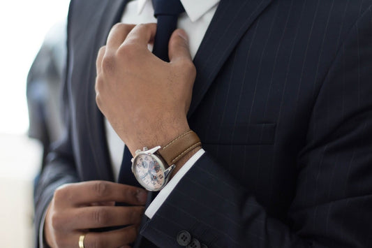 Man in a suit wearing a sleek dress watch, highlighting how the right timepiece enhances men’s fashion for any outfit and occasion.