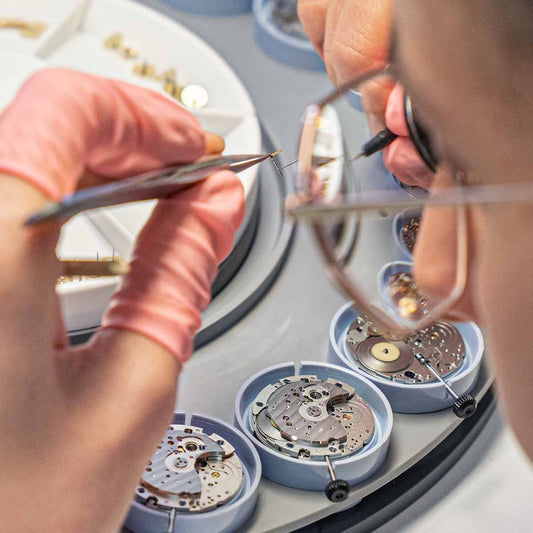 Close-up of a luxury mechanical watch movement showing intricate gears, balance wheel and fine craftsmanship in horology.